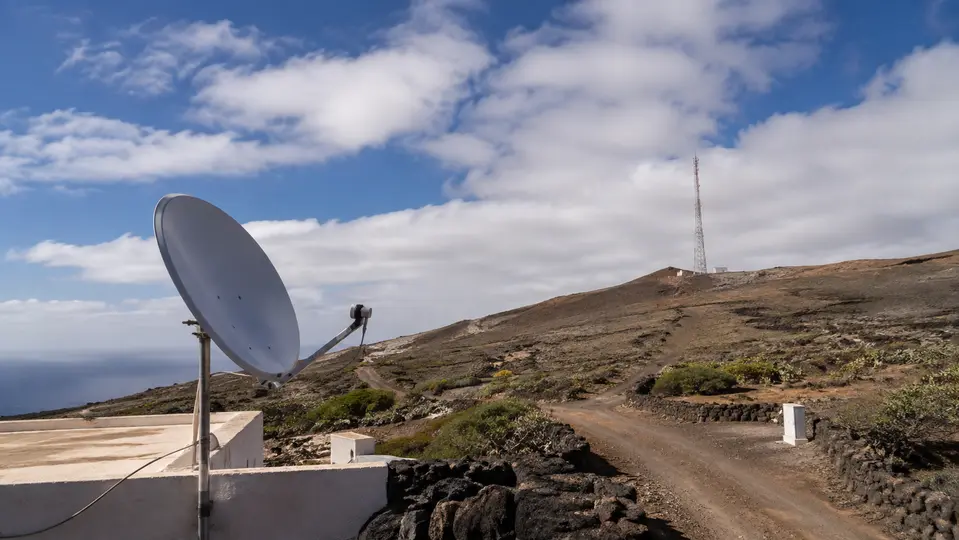 Antena satelital y torre móvil en una zona rural volcánica de Canarias
