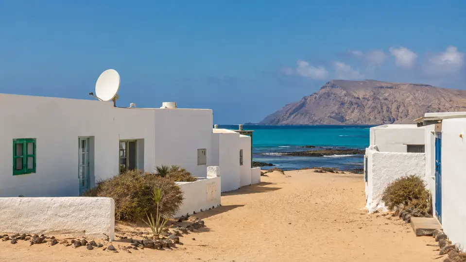 Casa blanca con antena satelital frente al mar en La Graciosa